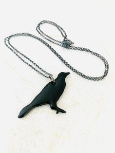 Crow Necklace - Dark Gray Enamel Bird NecklaceGray enamel fused to copper. Includes 18 inch Sterling silver chain. Swallow measures 1 1/4 inch in height 1 inch in width. Handle as glass Handmade in The Pacific Northwest 🐦 Crow Pendant, Crow Necklace, Black Crow, Bird Necklace, Bird Pendant, Bird Earrings, Bird Jewelry, The Pacific Northwest, Earrings Photo