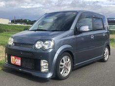 a small blue van parked on the side of a road