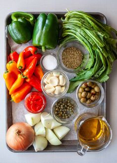 an assortment of vegetables on a tray with olives, peppers, and other ingredients