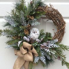 a wreath with an owl and pine cones