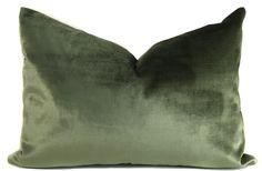 a green velvet pillow on a white background with the back turned to show it's side