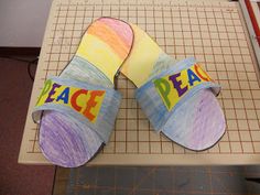 a pair of sandals that say peace and have been made out of paper on top of a cutting board