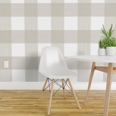 two white chairs sitting at a table with a potted plant on top of it