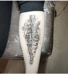 a woman's leg with a tattoo on it that has a castle in the middle