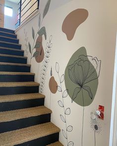 a stair case painted with flowers and leaves on it's side, next to the stairs