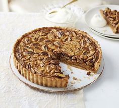 a pecan pie on a plate with one slice cut out and another half eaten