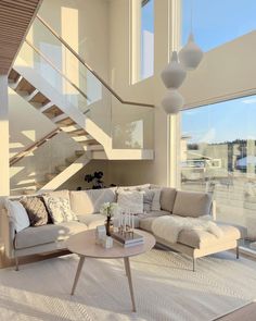 a living room filled with furniture next to a stair case in front of a window