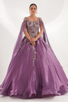 Purple attached cancan padded gown placement embroidered with sequins, cutdana, pearls, zircon and attached cape sleeves. - Aza Fashions Glamorous Organza Gown For Debutante Ball, Ball Gown With Intricate Embroidery And Fitted Bodice, Fitted Bodice Ball Gown With Intricate Embroidery, Embellished Organza Ball Gown Evening Dress, Satin Gown With Sequins And Fitted Bodice, Glamorous Organza Gown With Sweetheart Neckline, Glamorous Gown For Debutante Ball, Organza Embellished Ball Gown For Prom, Embellished Organza Ball Gown For Prom Season