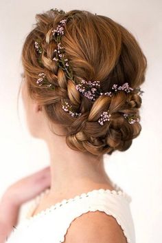 a woman with braids and flowers in her hair is shown from the back view