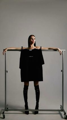 a woman standing behind a metal rail with her arms on it