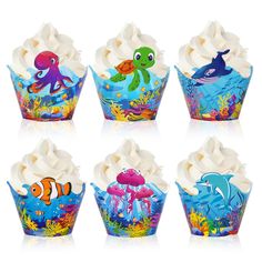 six cupcakes decorated with different sea animals and marine creatures on white frosting