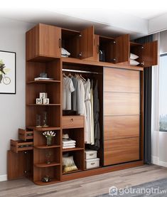 a large wooden closet with clothes hanging on the doors and shelves in front of it