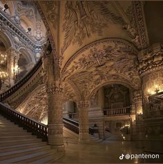 an ornate staircase with chandeliers and paintings on the walls in a large building