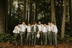 a group of men standing next to each other in front of trees