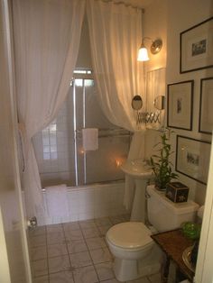 a white toilet sitting next to a bath tub in a bathroom under a shower curtain