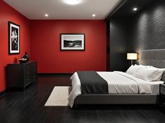 a bedroom with black and red walls, white bedding, and wooden flooring