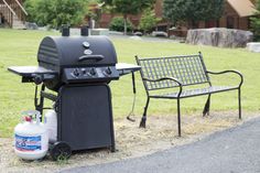 a bbq and chair sitting in the grass next to each other