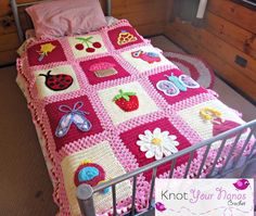 a crocheted blanket is on top of a bed with pink and white bedspread