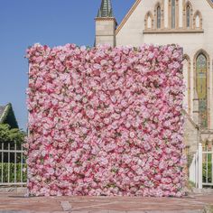 a large pink flowered wall in front of a church