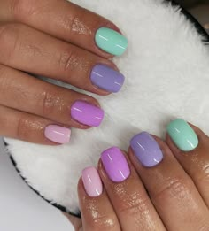 a woman's hands with purple, blue and green manies on their nails