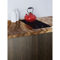 a red tea kettle sitting on top of a stove