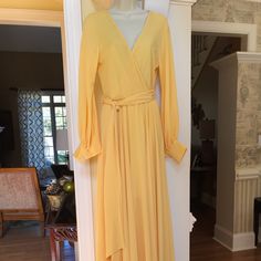 New Without Tag, Never Worn !!! Meghan La Lilly Pad Solid Maxi Dress. It Is A Canary Yellow Crepe Like Fabric. Has A Crossover Deep V Neckline That Goes To Elastic Waistline That Has A Long Fabric Tie Sash. Has Billow Long Sleeves With Three Pearl Like Buttons Cuff. A Full Flowy Bottom. It Is Lined To The Knee Area. It Is Considered A Maxi Dress But Is Very Appropriate For A Formal Affair. New Without Tag 125.00. It Is A Size Small. Chic Long Yellow Dress, Long Yellow Daywear Dress, Yellow Long Daywear Dress, Long Yellow Dress For Daywear, Lilly Pad, Solid Maxi Dress, Canary Yellow, Deep V, Crossover