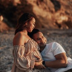 a man sitting next to a woman on the beach