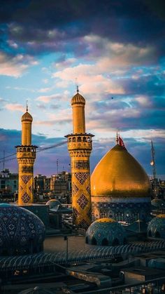 two large yellow and blue domes in the middle of a city at sunset or dawn