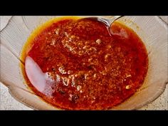 a glass bowl filled with sauce on top of a counter