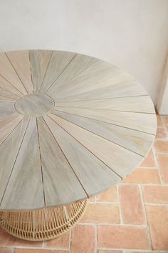 an umbrella shaped table sitting on top of a brick floor