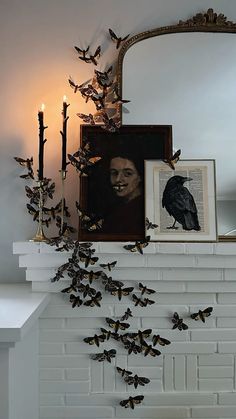 a fireplace with candles and pictures on the mantle