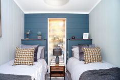 two beds in a small room with blue walls