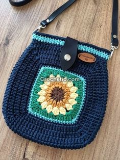 a crocheted purse with a sunflower on the front and blue trim around it