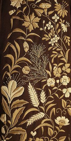 a brown table cloth with white flowers and leaves on it