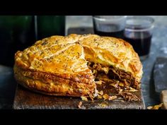 a meat and cheese pie on a wooden cutting board