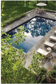 an empty swimming pool surrounded by lawn chairs