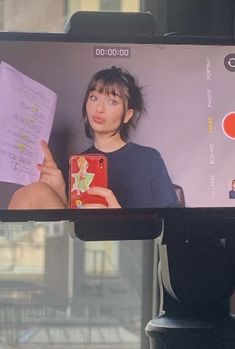 a woman is taking a selfie with her cell phone in front of the camera