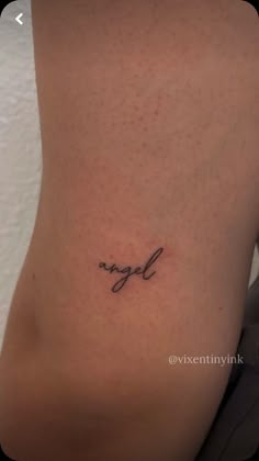 a small tattoo on the side of a woman's stomach that says, angel