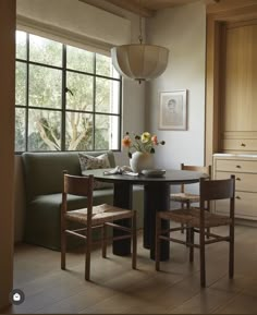 a living room with a couch, table and chairs next to a large open window