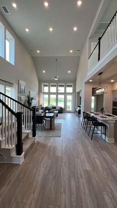 a large open floor plan with wood floors and white railings on the second story