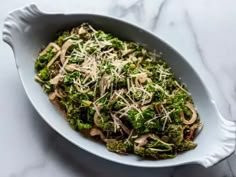 a white bowl filled with broccoli covered in parmesan cheese and onions