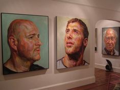 three paintings of men are hanging on the wall