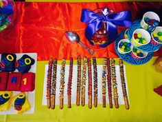 an assortment of candy and candies on a yellow tablecloth with red cloth behind it