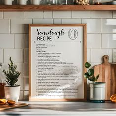 a recipe board sitting on top of a kitchen counter next to a potted plant