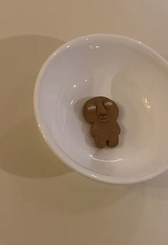 a bowl with a cookie shaped like a teddy bear in it