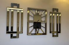 a clock mounted to the side of a wall next to two metal frames with bars on them