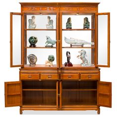 an old wooden cabinet with glass doors and figurines