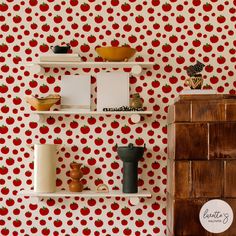 the wall is decorated with red apples and white shelves