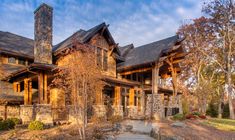 a large stone and wood house in the woods