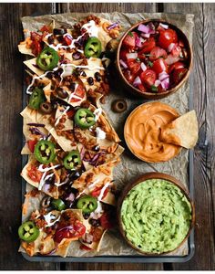 nachos, guacamole and salsa on a tray